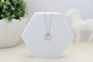 A sterling silver pendant in the shape of a horseshoe and heart with simulated diamonds