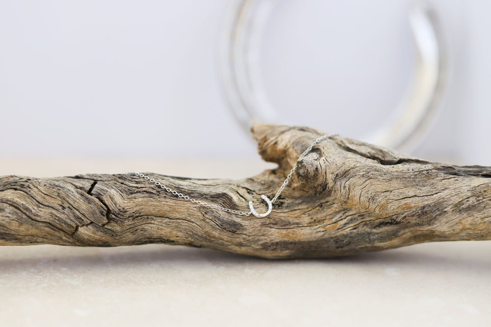 A sterling silver horseshoe-shaped bracelet with cubic zirconia decoration