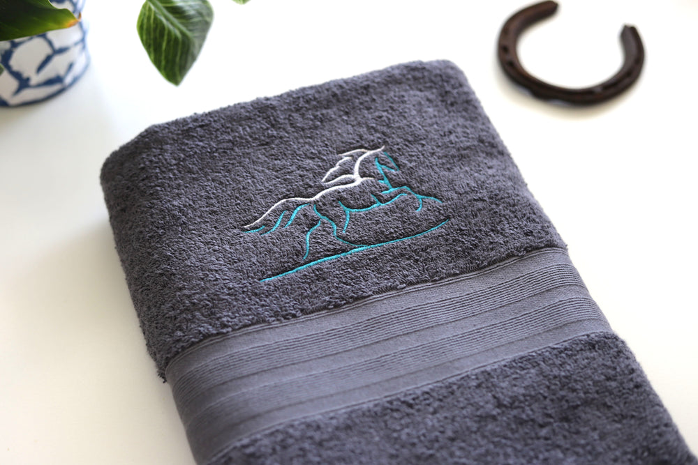 Close up of embroidered stylise horse on grey cotton bath towel - equestrian gift