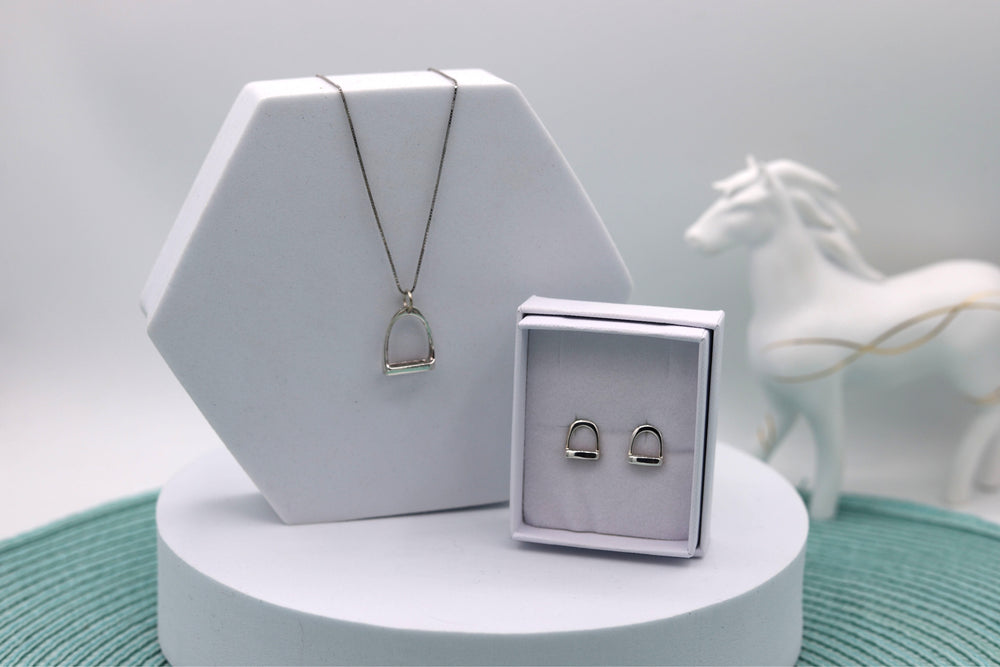 A Sterling silver jewellery set consisting of a stirrup pendant with a Sterling Silver rhodium plated chain and stirrup ear studs which are a perfect match to the pendant. They are presented in separate jewellery boxes 
