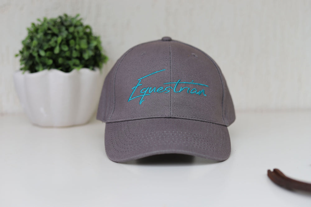 A grey baseball cap with 'Equestrian' embroidered in teal on the front