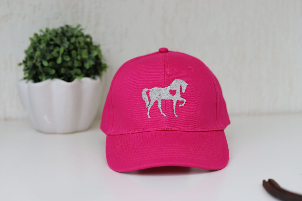 A hot pink baseball cap with an embroidered horse design and a crossover Velcro at the back