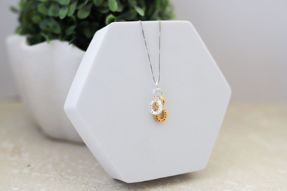 A Sterling silver two horseshoe pendant with a sterling silver rhodium plated chain