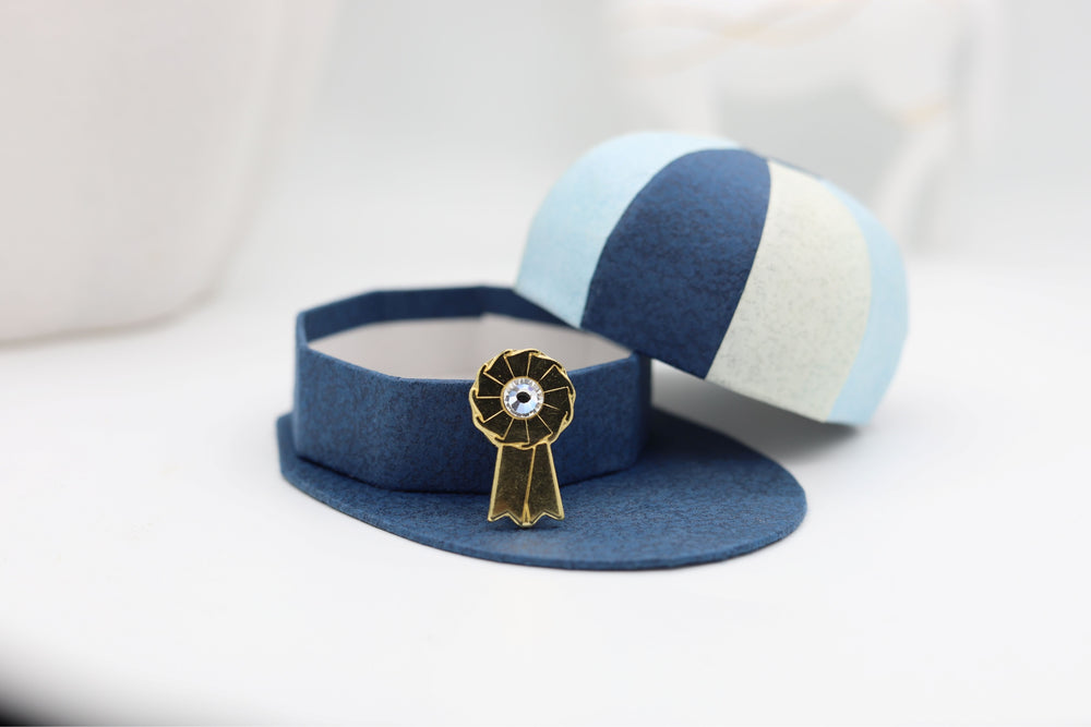 Gold coloured rosette brooch with hat display box